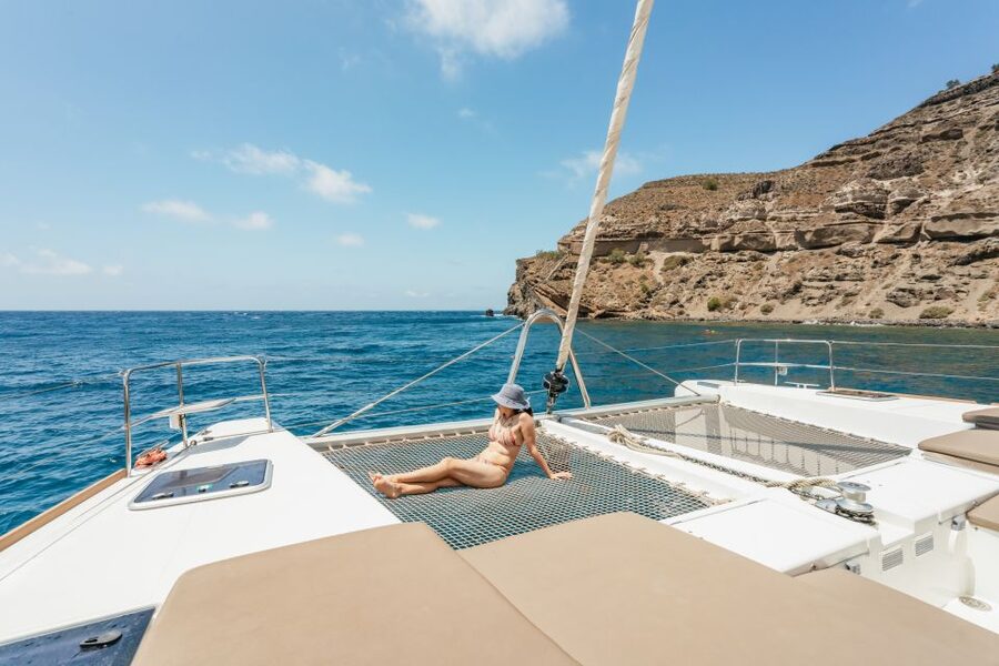 A catamaran at anchor off the Santorini caldera with the swim ladder down